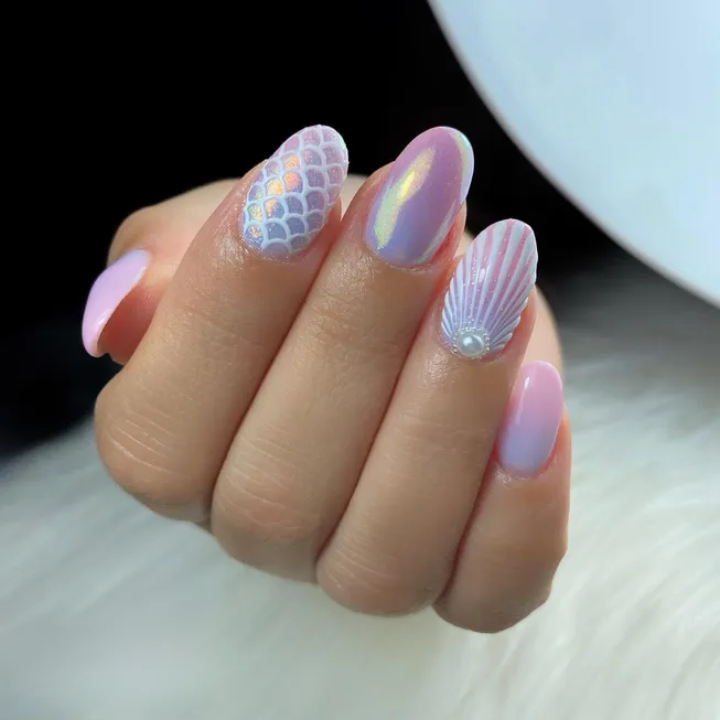 This beautiful image shows unique mermaid nails ideas, using a mix of holographic colors, a classic mermaid scale pattern, and a stunning 3D seashell design with a pearl.