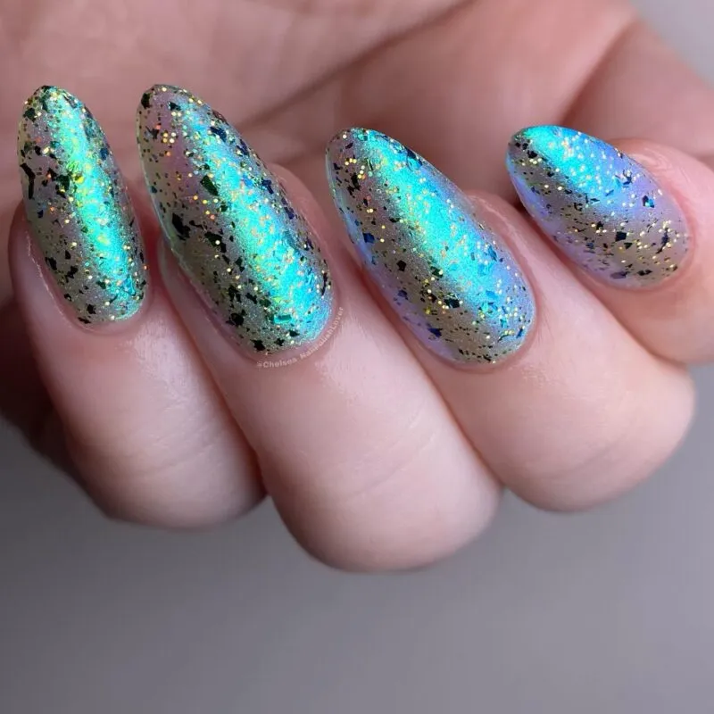 This stunning photo showcases a glittery take on mermaid nails ideas, with a color-shifting base and gold speckles that truly sparkle like the sea.