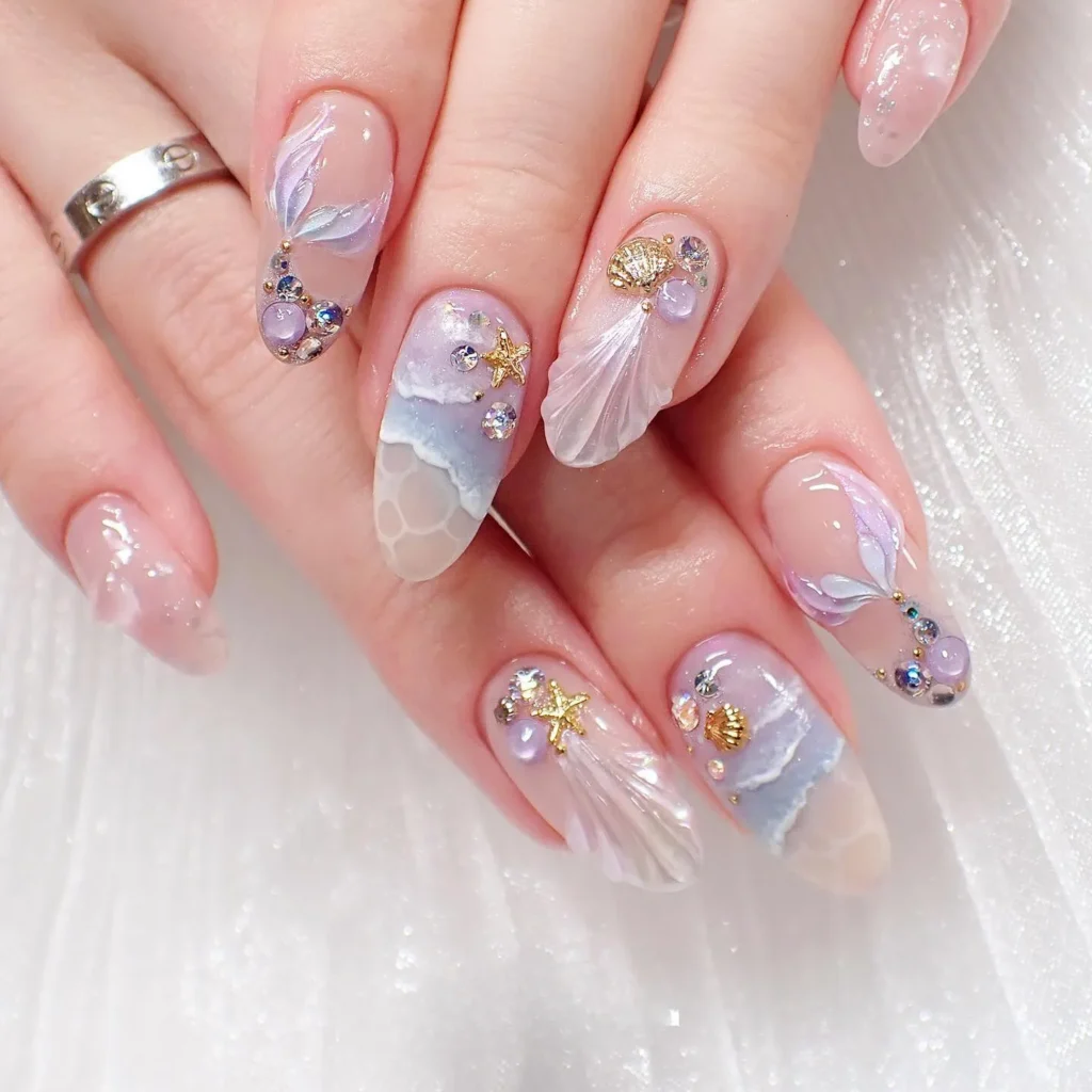 This beautiful image showcases a unique take on mermaid nails ideas, featuring soft, iridescent pastels, delicate seashell and starfish charms, and sparkling gems that mimic the ocean's magic. It's a dreamy and elegant look.