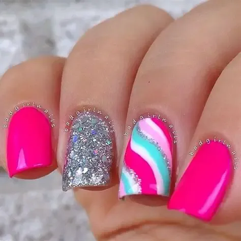 This bright image showcases playful mermaid nails ideas, using vibrant neon pink, sparkling silver glitter, and a fun turquoise and pink striped accent nail.