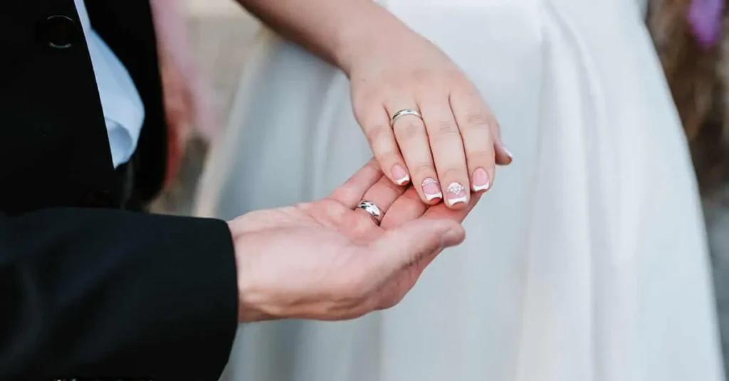 A beautiful wedding nail design adds a perfect finishing touch, as seen in this photo highlighting the bride’s elegant hands.