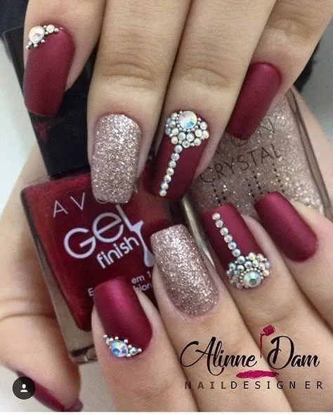 A stunning manicure with matte maroon and glitter wedding nails, featuring elegant crystals and a gold sparkle.